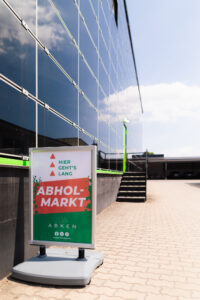 Wegweiser zum Abholmarkt der Heinrich Abken GmbH vor dem Gebäude
