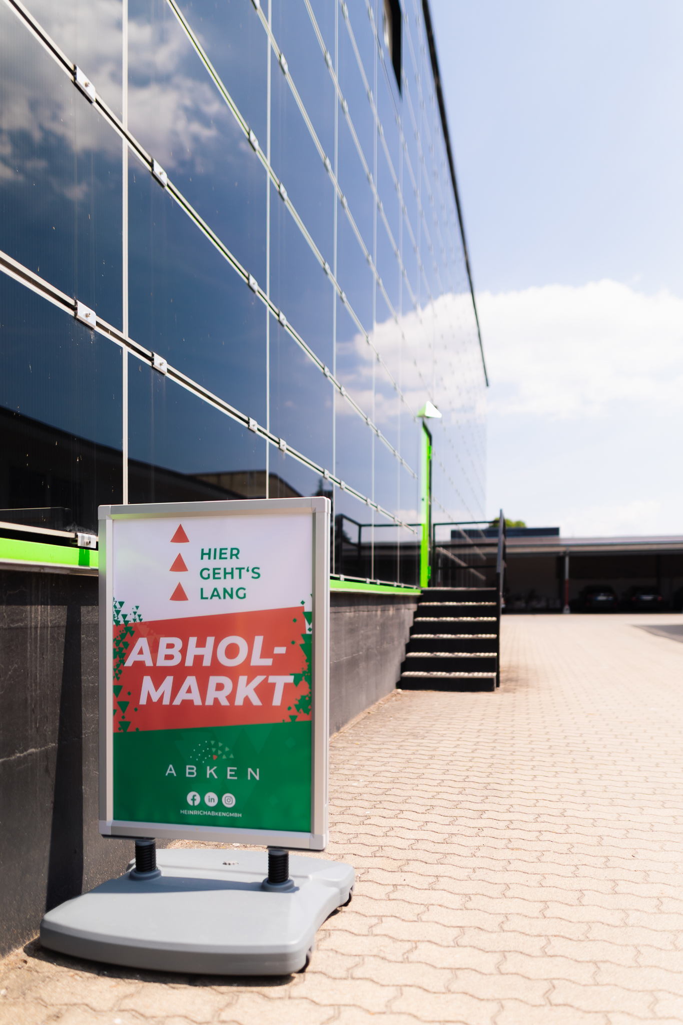 Wegweiser zum Abholmarkt der Heinrich Abken GmbH vor dem Gebäude